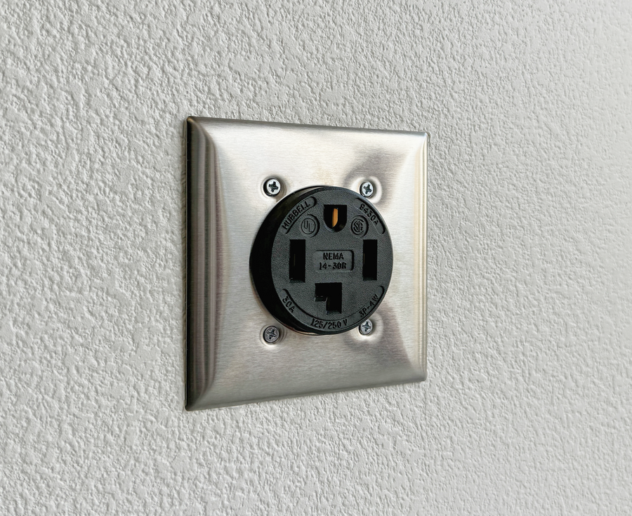 A NEMA 14-30 dryer outlet on a wall. The bottom slot is L-shaped.