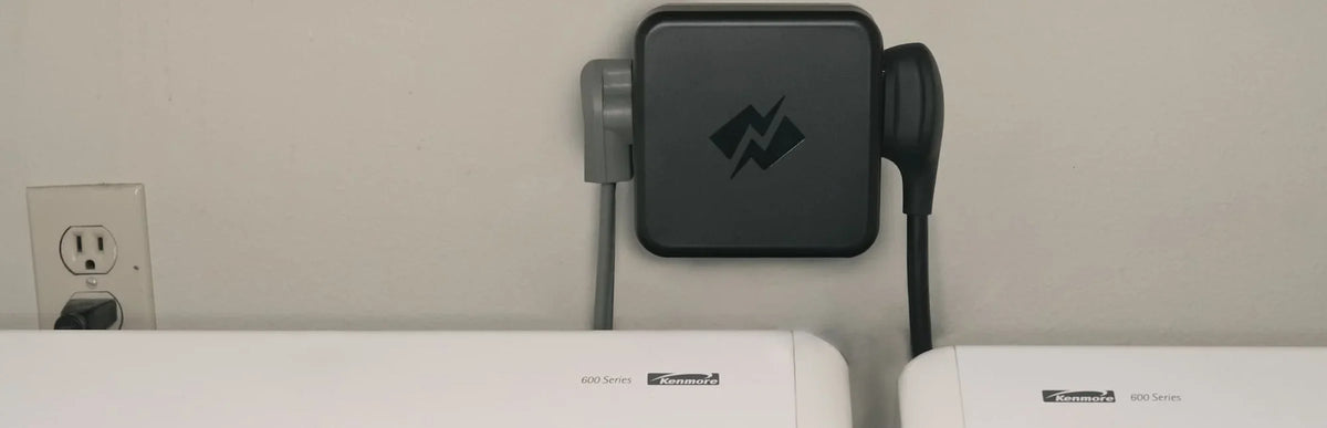 NeoCharge Smart Splitter mounted above a washer and dryer, with the dryer and EV charger cords plugged into it